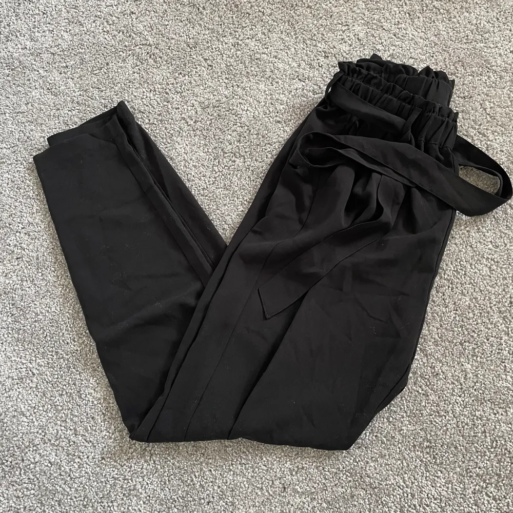 Svarta kostymbyxor med snörning i midjan från BikBok. Storlek S. Jeans & Byxor.