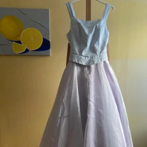 Balklänning säljes - Ljusblå aftonklänning med askungekänsla. Matchande sjal medföljer. Dold dragkedja baktill Märke: Poly Tillverkad i USA Storlek: M  passar  för en person för ca 160-170 cm lång.   Material: polyester Kemtvättas Använd två gånger, som ny. 