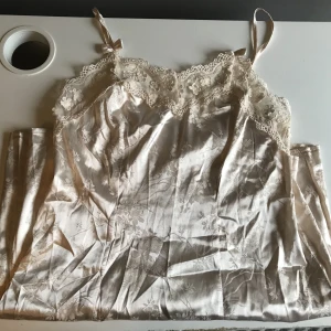 Satin klänning - Så söt satin klänning med spets vid bysten och små rosetter på axelbanden! Säljer då jag tyvärr inte haft tillfälle att använda den. Bara att meddela mig via dm vid eventuella frågor och funderingar! 