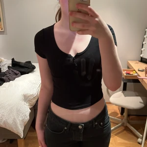 Svart t-shirt med knappar från H&M  - Jättefin croppad topp från Ginatrico som tyvärr inte kommer till användning längre. Skriv för fler bilder eller om ni har några frågor 🤍