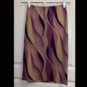 Snygg kjol från taboo - Riktigt snygg kjol med unikt mönster, färgerna är så himla fina! Är lite osäker på storleken men då den är stretchig så skulle den passa M och L, möjligtvis en s också!