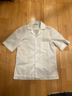 Acne Studios Short Sleeve Shirt  - Acne Studios kortärmad skjorta med ljusgula broderade detaljer.