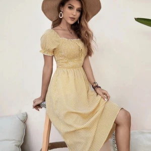 Gul rutig klänning - Gul rutig klänning med smockning över bysten och fyrkantig urringning. Köpt på Shein i storlek M. Använd 1 gång men otroligt skön och luftig. Köpt för 149 kr.