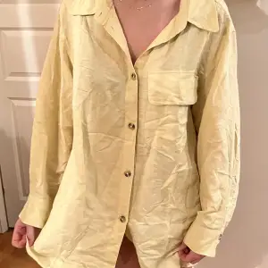 En ljusgul/beige oversized linneskjorta från hm i strl M