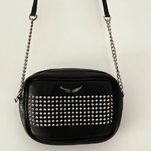 Zadig & Voltaire väska - Sjukt cool Zadig & Voltaire väska som jag säljer då den inte längre kommer till användning. Den är rymlig och i bra skick , lätt slitage på själva kedjan på axelremmen. Sista bilden är lånad för att ge en uppfattning om väskan storlek! Nypris ca 3500 SEK💞