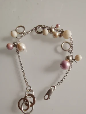 Äkta silver armband  - Äkta silver armband med fejk vita och rosa pärlor i använd scick. 21 cm 