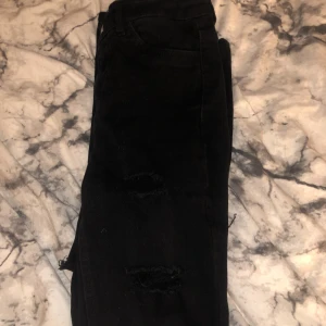 Slitna Jeans - Ett par skinny-jeans med mycket hål i knäna, högmidjade och i bra skick.