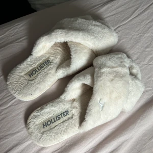 Tofflor  - Säljer dessa sjukt sköna tofflor från hollister! Väldigt bra skick har ej använd de så mycker för har ett par andra. Storklek 38-40 jag har 39 o de passar perfekt💗