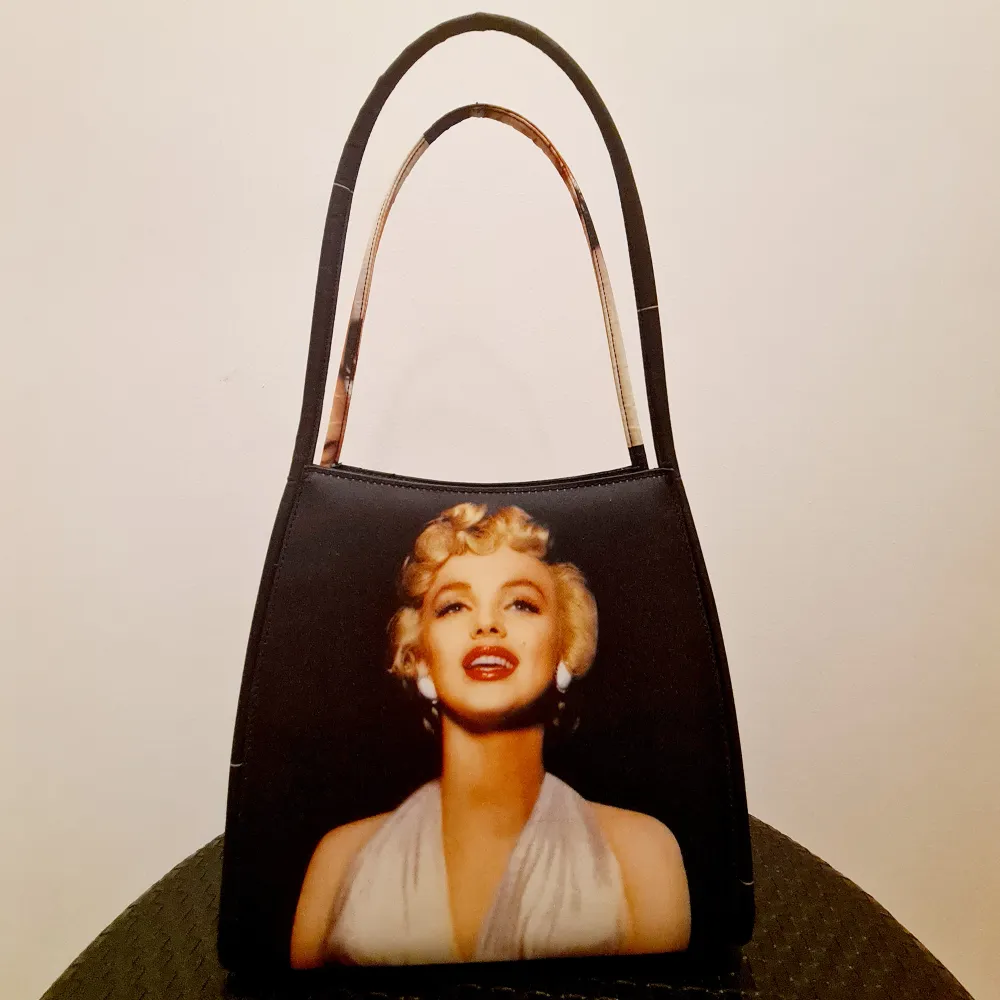 Handväska med Marilyn Monroe tryck. Oanvänd i nyskick som har stått i garderoben för länge. Väntar på ny ägare som vill använda den. <25×40cm. Väskor.
