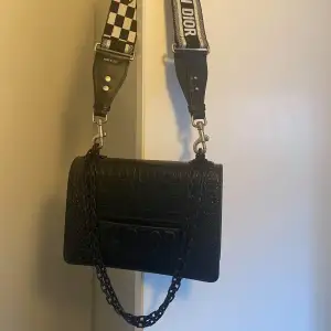 Säljer denna väldigt fina crossbody väska från Christian Dior i svart krokoskinn. 100% äkta läder. Axelrem i tyg som går att ta av och man kan även bära med kedjan som axelrem. Väldigt fin, knappt använd, som ny! AAA-kopia.  Dustbag finns 😊  