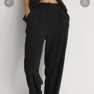 Randiga kostymbyxor NA-KD - Kritstrecksrandiga kostymbyxor från NA-KD i storlek 36. Använda ett fåtal gånger, nypris 429kr