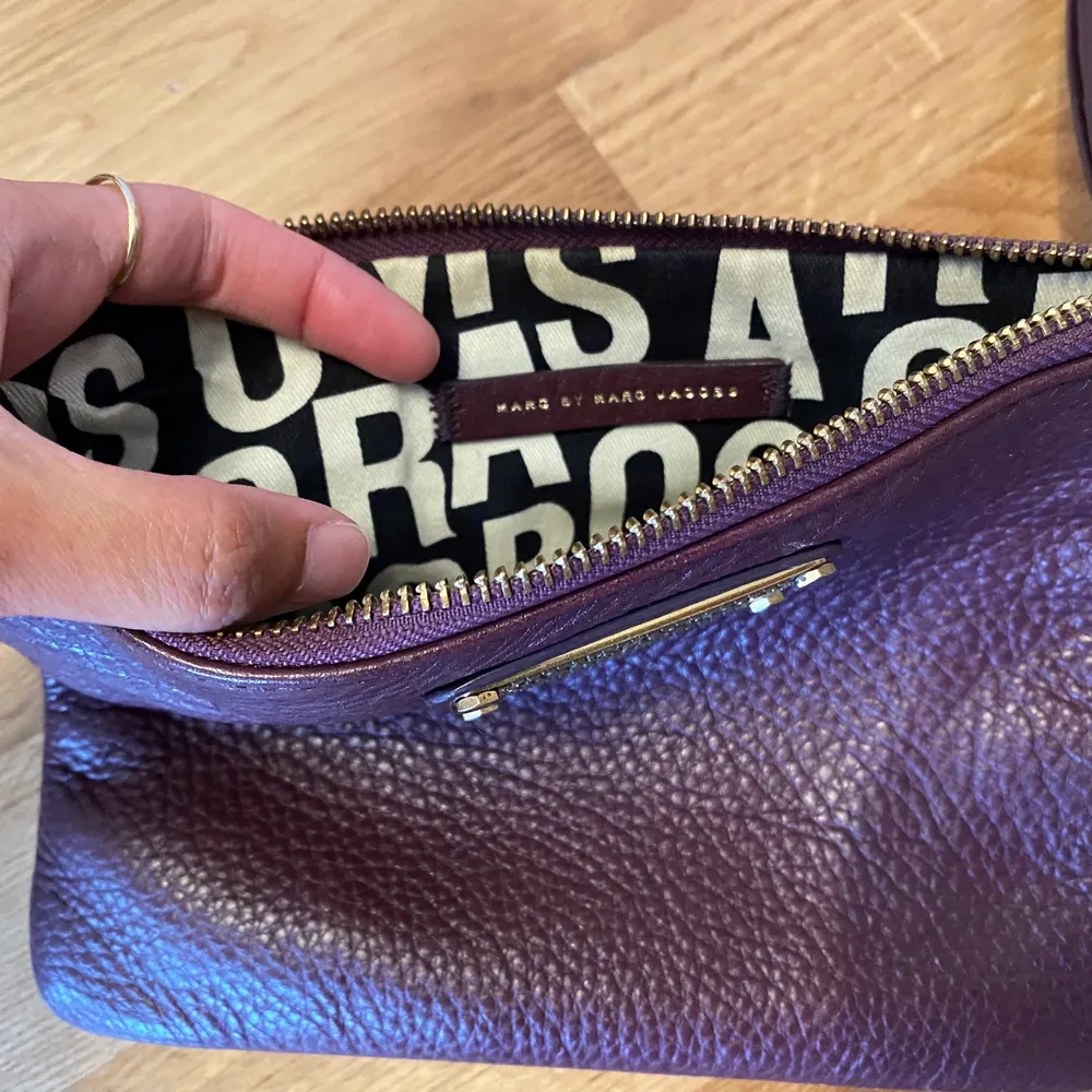 Säljer den här fina väskan/clutchen i läder från Marc Jacobs. Färgen är mörklila/vinröd/aubergine. Den är i perfekt skick!  Mått: 21 x 6,5 cm. Väskor.