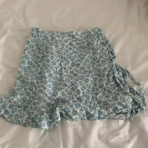 Kjol från PULL & BEAR - Kjol från PULL & BEAR som jag säljer eftersom att den inte passar mig längre. Den har resor på sidan och har en grön blå färg med blommor