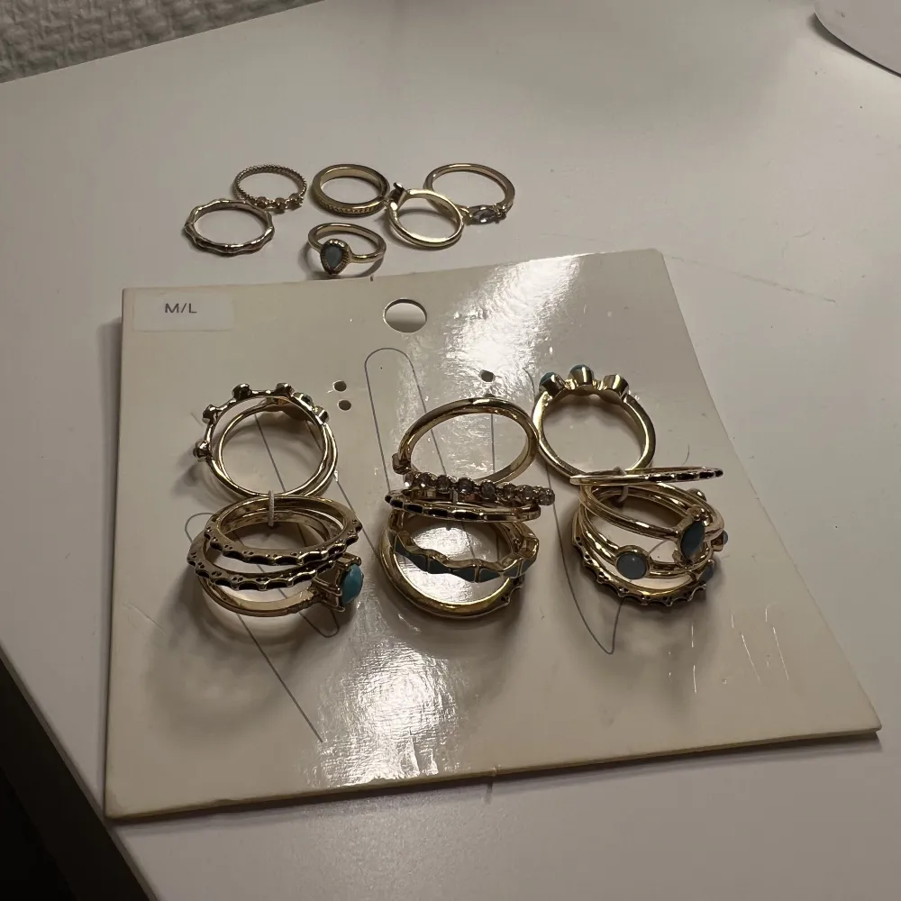 Guldringar från HM. Säljer då de är för stora för mig. Ringarna är aldrig använda. De mindre ringarna är till för att ha på övre del av fingrarna och de är endast provade och inte användna. Ingen av ringarna har tappat färg. Vissa har blå ”sten” detaljer . Accessoarer.