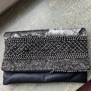 Twist & tango clutch inköpt på deras butik i Göteborg. Har gått sönder längst ner, se bild. Men går absolut att använda ändå och om man är pillig, är det lätt fixat.   Den är väldigt rymlig och man får med sig allt man kan tänka sig på en utekväll! 