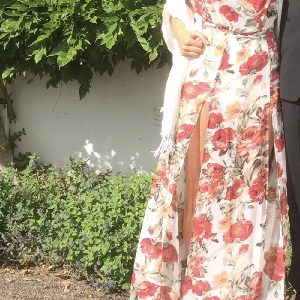 Drömklänningen i blommigt fint tyg med öppen rygg och slits på framsidan. . Mekot.