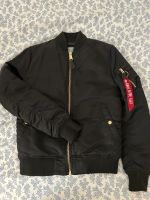 Bomberjacka  - Säljer min nästintill nya bomberjacka från Alpha Industries! Den är enbart använd ett fåtal gånger så i nästan i nyskick. Ny pris ligger runt 1800 kr 