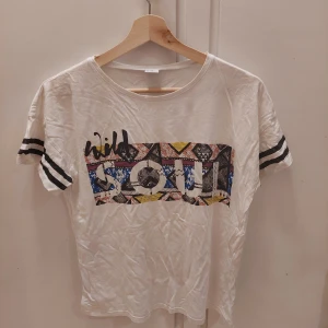 H&M kids, 170 - En vit t-shirt med tryck från H&M i st 170 men skulle passa S-M. Den är i bra skick, då den knappt blivit använd. 25kr+frakt