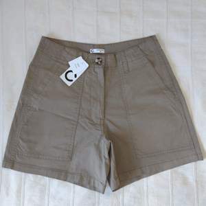 Oanvända khakifärgade shorts från Cubus (modellen heter Zahara). Så snygga och användbara. Högmidjade med stretch, gjorda av ekologisk bomull (98% bomull och 2% elastan). Storlek 38.