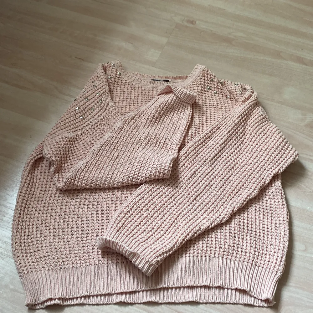 En rosa sweatshirt som är stickad med nitar på axlarna. Tröjor & Koftor.
