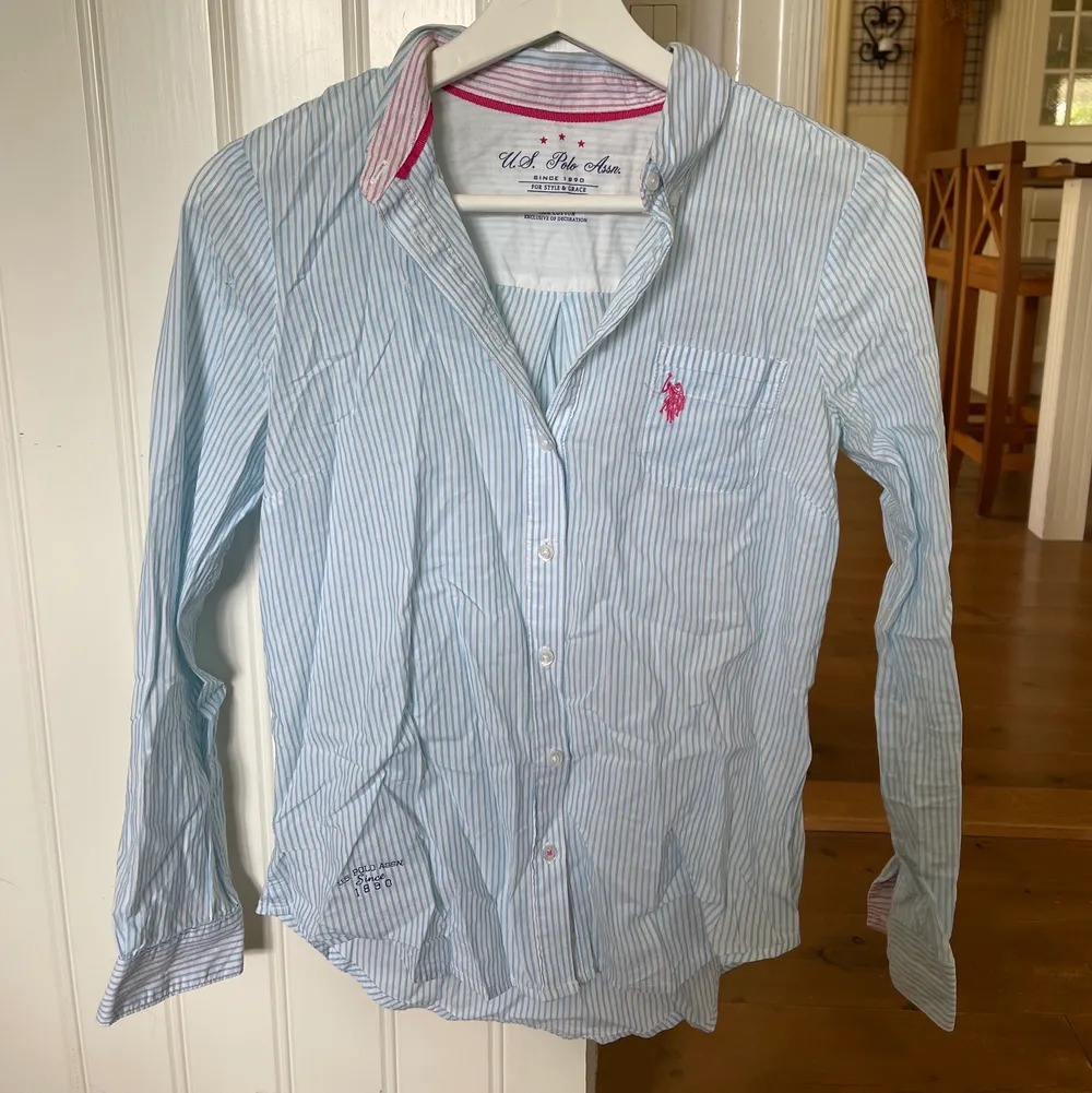 Ljusblå-vit randig skjorta med rosa detalj. Fint skick! . Skjortor.