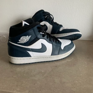 Jordan 1 mid dark teal - Tjena! Säljer ett par Jordan 1 mid dark teal i stl 41. De är använda vid endast några enstaka tillfällen och är i väldigt fint skick. De har inga skador eller andra defekter. Box medföljer och priset går självklart att diskutera. Köparen står för frakten.