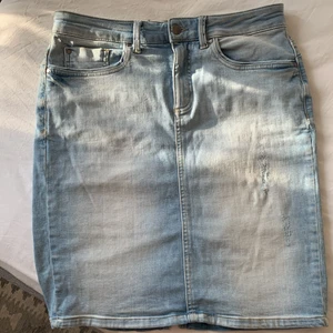 Kjol från saint tropez - Jeanskjol i stretchigt material från Saint Tropez. Storlek M.  Dekorativa slitningar på bakficka och vänster fram. 