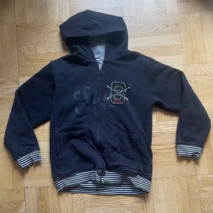 Svart zip up - As snygg zip up hoodie med detaljer på. Jätte mysig och har fluff inuti. Varm, gosig och snygg!! Få defekter vid slutet av armarna  