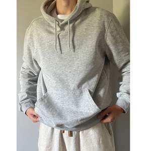 En grå Hoodie realaxed fit storlek M,  Säljer för används inte och har endast använt några gånger.  Bra kvalite och inga skador på den.  Jag är 180 Och den sitter bra på mig.  Skriv för fler bilder eller frågor 🙌🏼