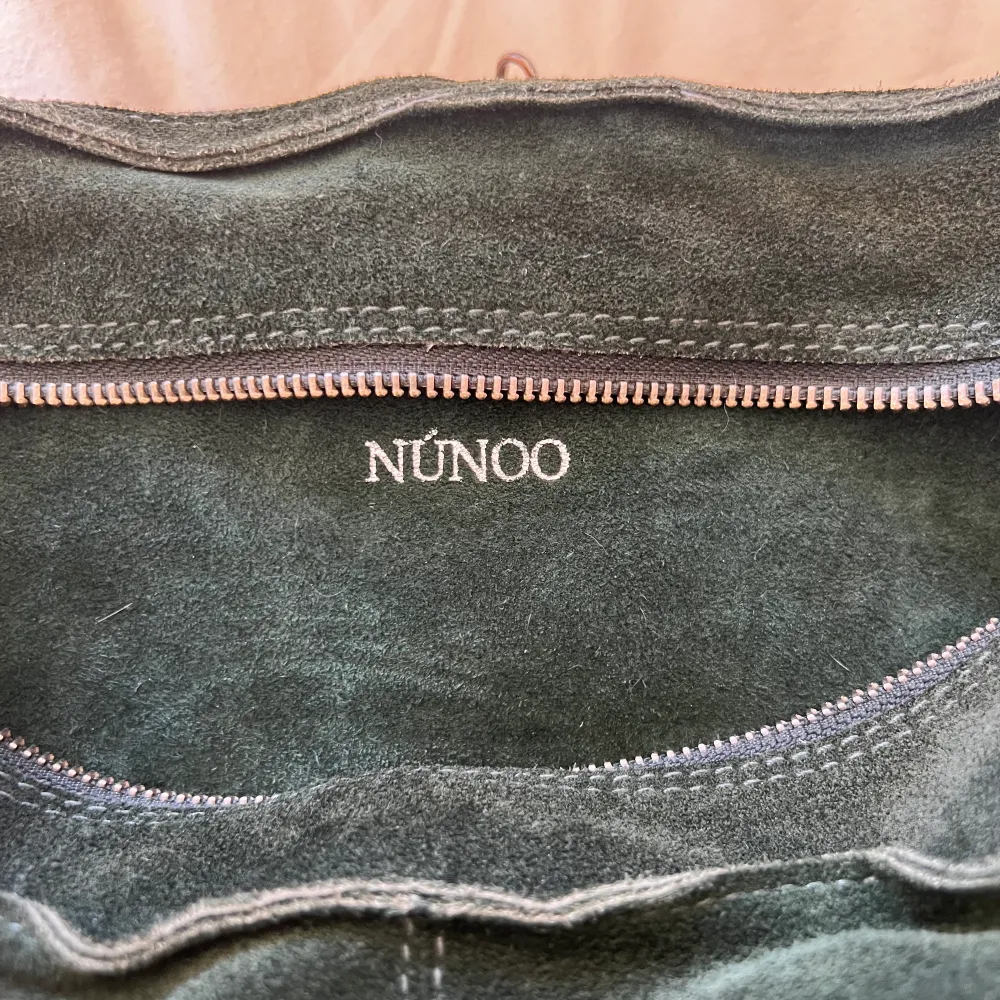 Skit snygg och rymlig Nunoo bag i mörk grön/camogrön!⚡️ Köpt ny från Nunoo’s hemsida och är i jättefint skick. Väskan är i Mocka och bör undvika vatten/regn så mycket som möjligt, för att hålla den fin!💋 Ett långt axelband tillkommer i samma färg👍🏼. Väskor.