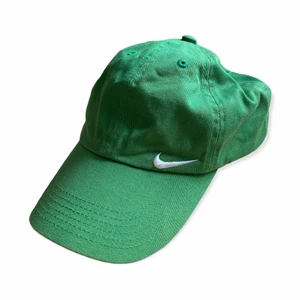 Grön Vintage Nike Keps - En snygg vintage nike keps i fint skick. Storleken är Kids One Size men den passar bra på mig som har storlek 54. Går att spänna åt till mindre eller större. För bilder på eller andra frågor var god kontakta mig 😃 Frakt sker via PostNord 51 kr spårbart 📦