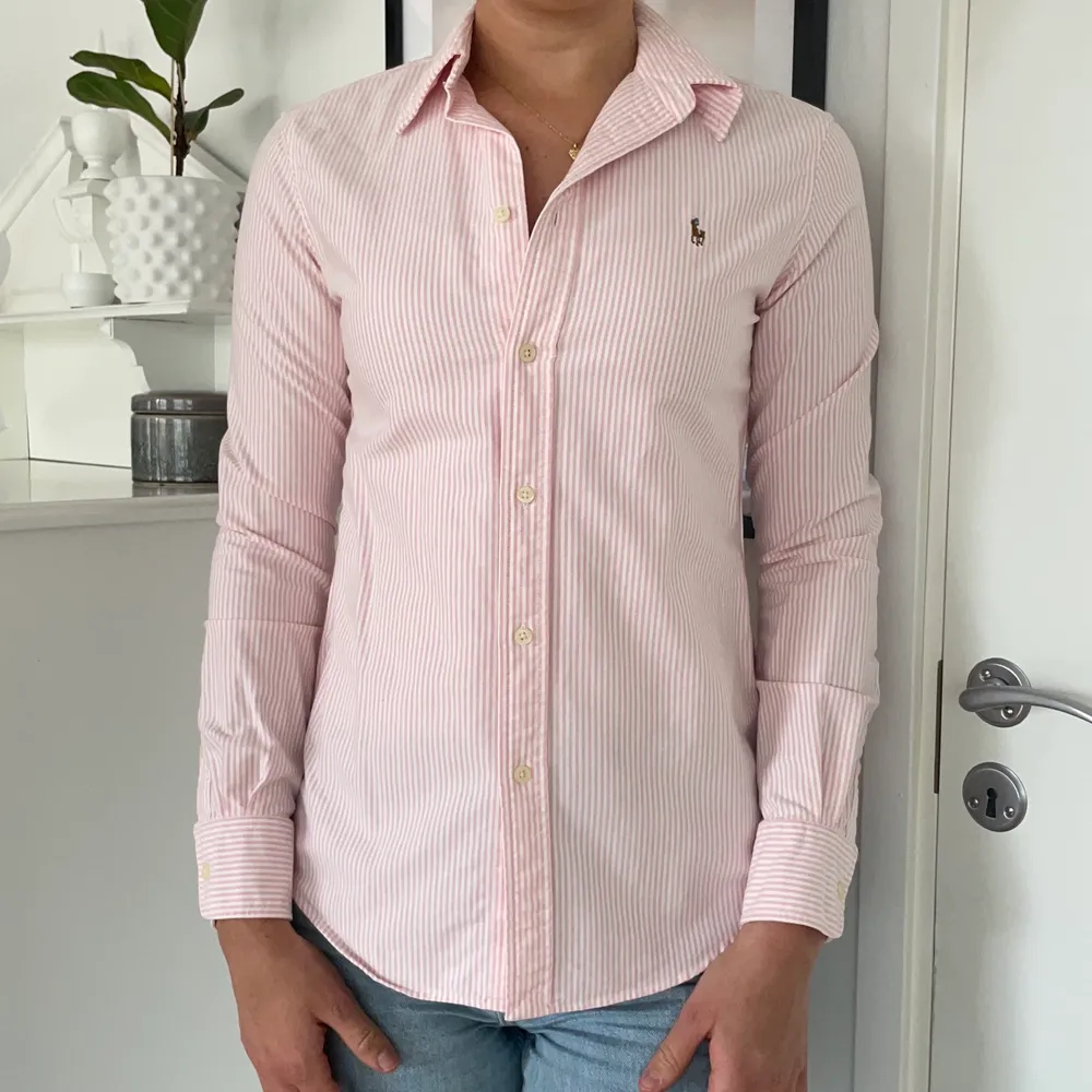 Rosa/vit randig skjorta från Ralph lauren köpt i usa. Modellen är figursydd (custom fit). Storleken är S/P och jag är 178cm lång. Väldigt fint skick . Skjortor.