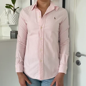 Ralph lauren skjorta - Rosa/vit randig skjorta från Ralph lauren köpt i usa. Modellen är figursydd (custom fit). Storleken är S/P och jag är 178cm lång. Väldigt fint skick 