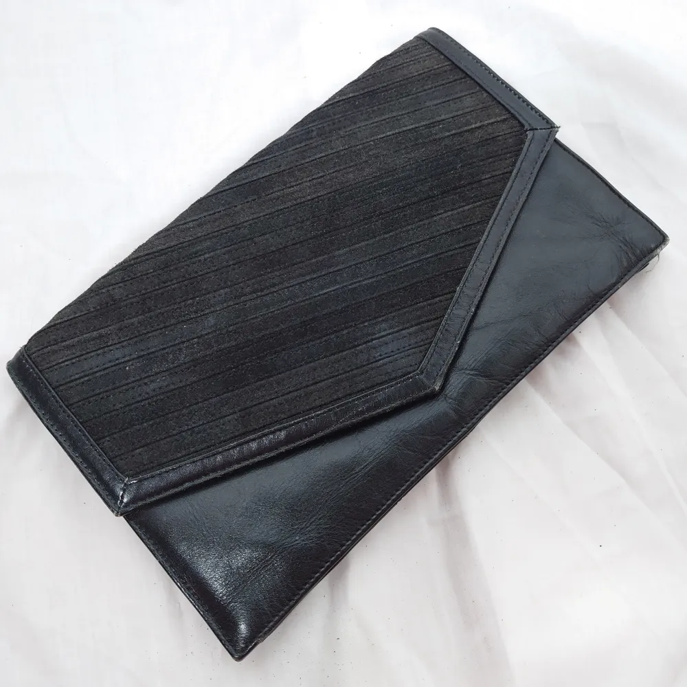 En svart äldre kuvertväska i skinn med mockamaterial på locket, 100kr🌱   En plånbok från River Island, 90kr 🌱. Väskor.