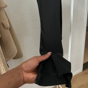 Svarta ribbade byxor med slits - Jag är 172 för referens, och dom gick ner till foten på mig men på benen är dom stora då jag inte har storleken i dagsläget. Köpta på Boohoo, aldrig använda endast testade. Har slits med dragkedja. 