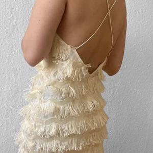 Klänning - Jättesöt fransad midi-klänning perfekt till festligare tillfällen. Strl 40 men passar nog mindre och större beroende på hur man vill att den ska sitta❣️ korsad rygg. Sista bilden ser du tydligare bild på fransarna. Fransarna står åt lite olika håll men går nog att fixa om man stryker klänningen