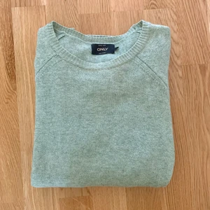 Grön stickad tröja - Säljer denna mjukt stickade tröja ifrån Only (Vero Moda) då jag knappt använder den. Väldigt fint skick och superskönt material. Tröjan har en grönmelerad färg och ribbstickade kanter.