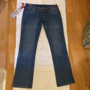 Snygga lowrise jeans med tagen kvar! Helt nya och oanvända🙌🏼 mycke snygga detaljer. 82cm runt midjan, innerbenslängd 79cm. Jag är 165cm lång. Bara att fråga om man har nå frågor!
