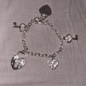 Armband - Super fint armband med berlocker. Köpt på second hand men aldrig använt själv. Har tyvärr lite rost på båda hjärtarna💞