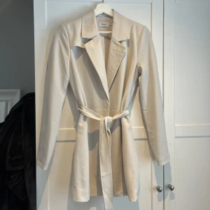 Beige kappa - En lite kortare kappa i blazermodell med knytskärp från ONLY i strl XS men passar mig som vanligtvis har S. Helt oanvänd så säljer då den endast hängt i gaderoben utan användning 💛