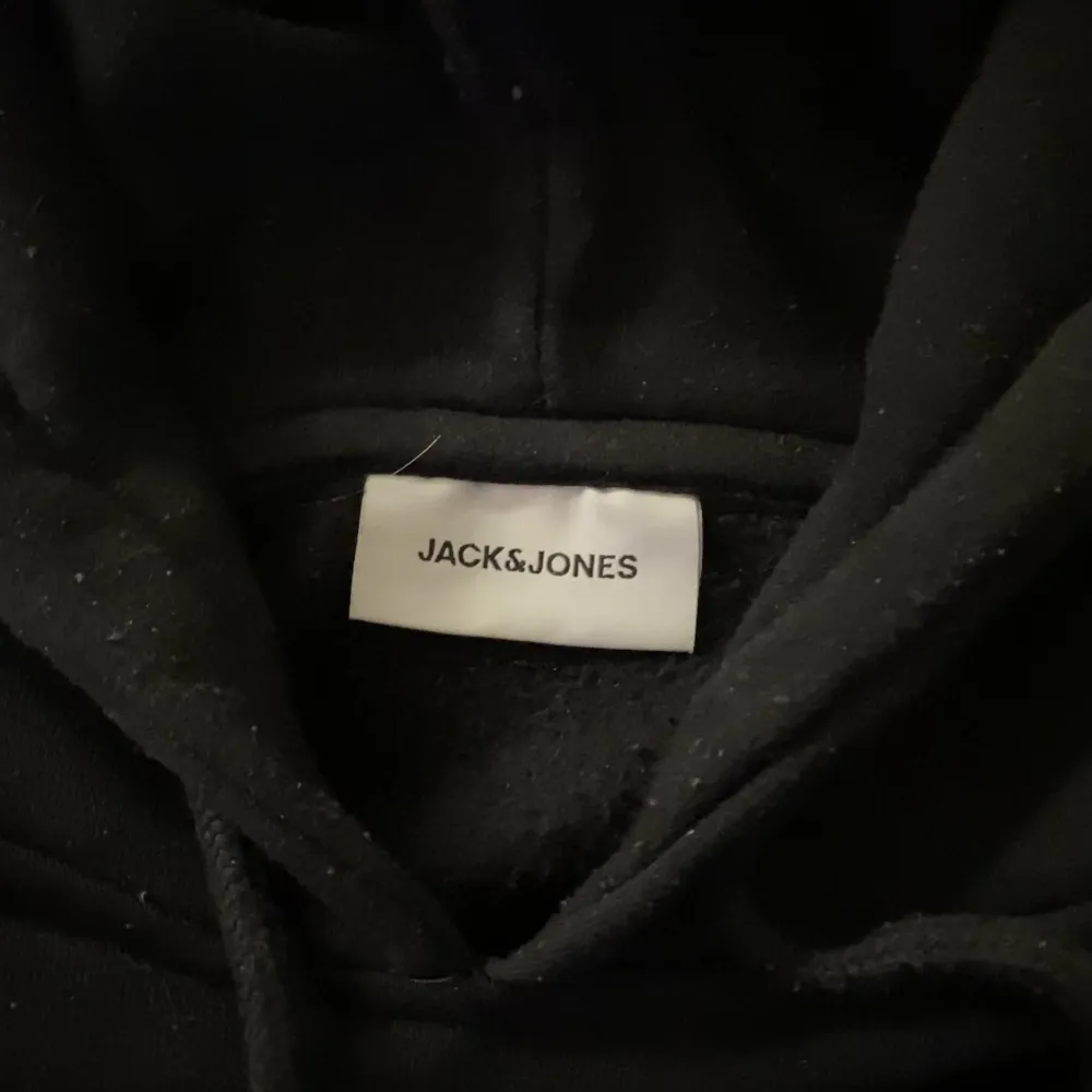 Svart hoodie med brodyr ifrån Jack&Jones köpt i höstas. Storleken är L men sitter som M. Knappt använd utan skador.. Hoodies.