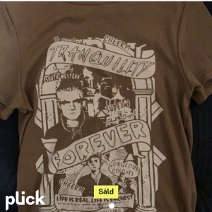 T-shirt med tryck  - En tajt T-shirt med tryck köpt här på plick. Står inget märke på tröjan men storleken är S-M. Köparen står för frakt!