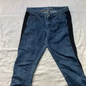 Michael kors jeans med en svart stretchpanel på båda sidorna. De är skinny ochlågmidjade. De är använda men i okej skick, säljer då de inte används längre.