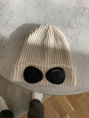 Cp company mössa  - Säljer en snygg cp vit mössa för bara 1000kr. Helt nytt i skick. DEN ÄR ÄKTA. (FRAKT GRATIS) ✨