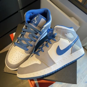 Jordan 1 Mid ”True Blue” - Säljer dessa Jordan 1 Mid ”True Blue”. De är helt nya och oanvända. De köpta ifrån JD Sports och givetvis äkta. Storlek 36,5. Bara att höra av sig vid frågor!