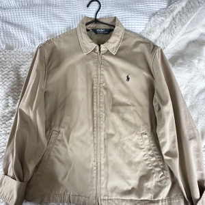 Ralph lauren jacka  - I bra skick 7/10. För dig som vill ha en jacka med kvalitet, stil, märkeskänsla och funktionalitet. På etiketten står det XL men det är L i verkligheten, lite för oversize för mig. Har en liten fläck på vänster sida, se bild.  Skriv om du undrar något :)