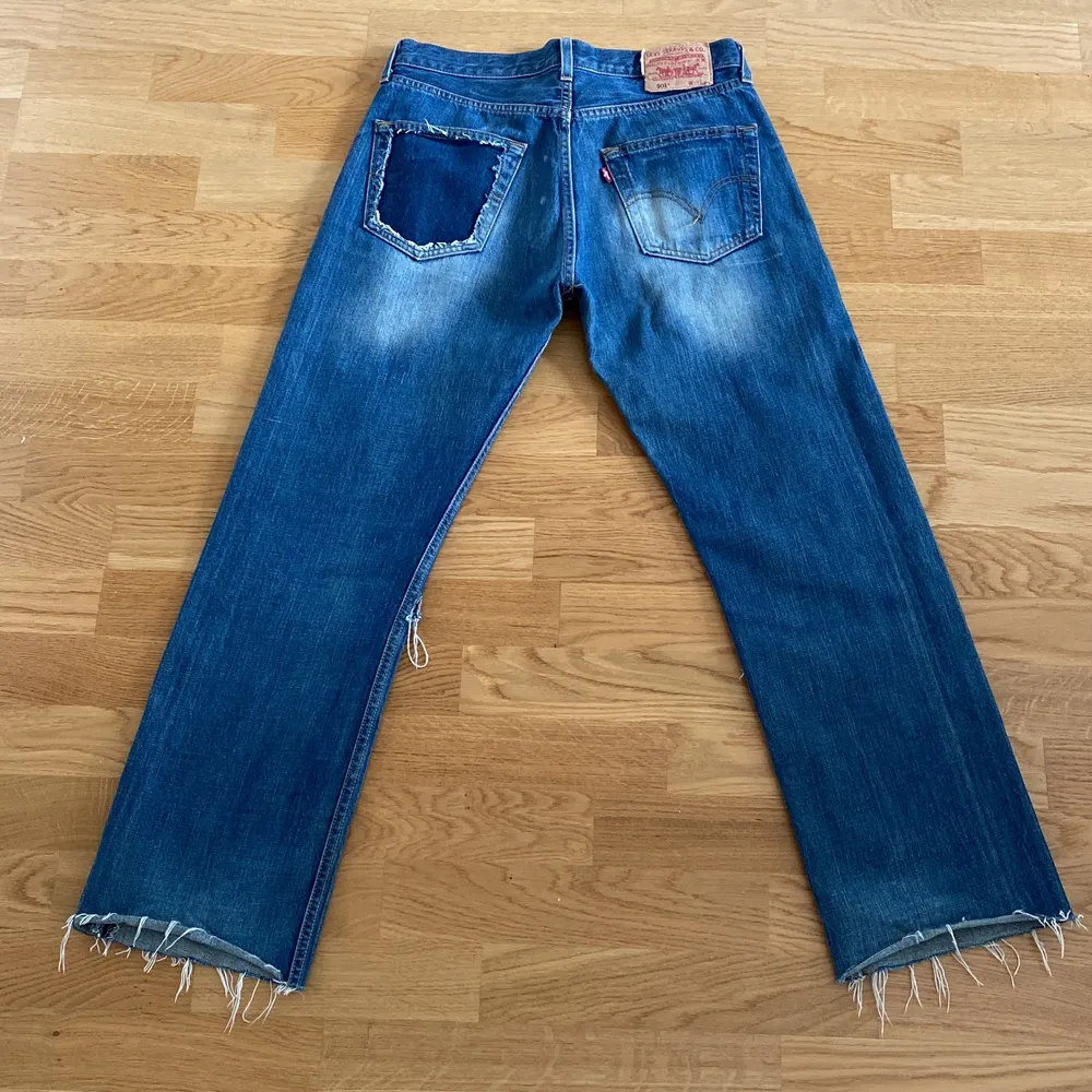 Ett par Levis jeans som är lite unika. Dem är klippta vid smalbenet och vänstra bakficka är urklippt  Storleken är 31/34 men jeansen är uppklippta så jag skulle säga att storleken är 31/32. Jeans & Byxor.