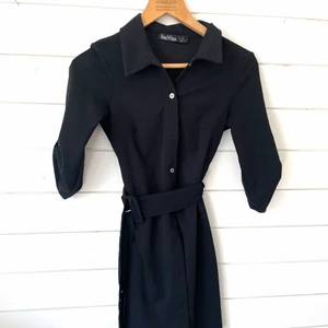 Skjortklänning  - Superfint skjortklänning med tillhörande band, använd 1-2 ggr! Klänningen går ungefär till knäna, storlek S