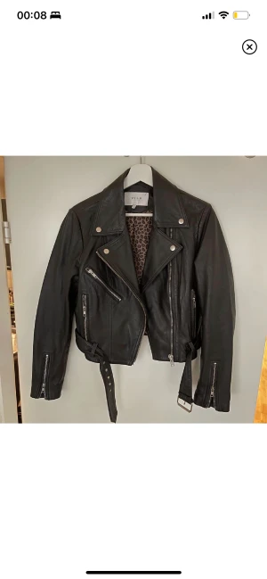 Äkta skinnjacka, favoriten, 36 - Min favoritjacka i skinn. Den är SÅ mjuk och sitter galet snyggt! Tänkte kolla om någon har intresse för denna. Välanvänd och i beg. skick. Ett litet jack i skinnet, bild 3. Färgen är sliten på ärmarna och några sömmar. Strl36 från Vila. Mer bilder finns.