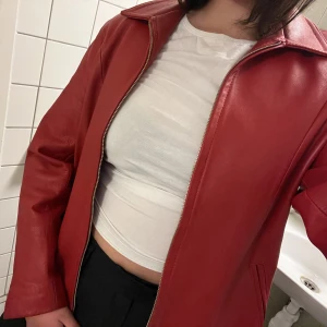RÖD LÄDERJACKA - Säljer en röd läderjacka (äkta läder) fint skick, endast en pytteliten skada (se sista bild). Strl: M/L, kan bäras lika väl som en one size. Kom gärna med prisförslag :) 